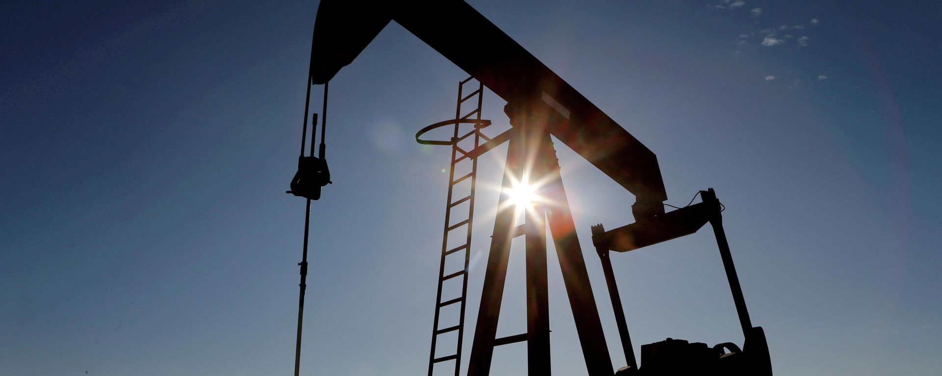 The sun is seen behind a crude oil pump jack in the Permian Basin in Loving County, Texas, U.S., November 22, 2019 - Sputnik International, 1920, 07.11.2021