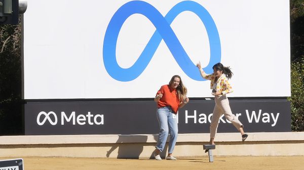 Facebook employees take a photo with the company's new name and logo outside its headquarters in Menlo Park, California on 28 October 2021 after the company announced that it is changing its name to Meta Platforms Inc.  - Sputnik International