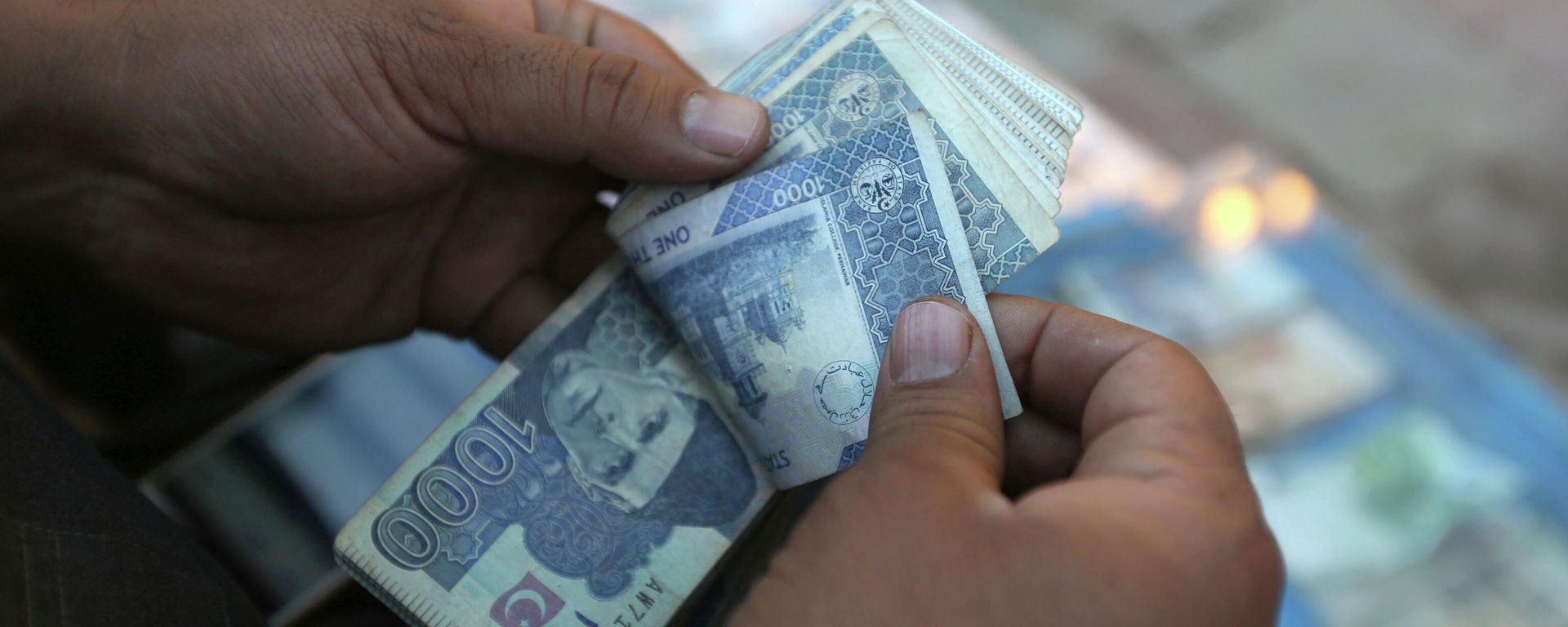 In this Monday, Dec. 5, 2016 photo, an Afghan money changer counts Pakistani currency banknotes at a money exchange market in Kabul, Afghanistan. Afghans are increasingly uncertain about their future, less confident in their government and more pessimistic than before on issues such as security, corruption, and rising unemployment, according to the annual survey by the San Francisco-based Asia Foundation released on Wednesday, Dec. 7, 2016. (AP Photo/Rahmat Gul) In this Monday, Dec. 5, 2016 photo, an Afghan money changer counts Pakistani currency banknotes at a money exchange market in Kabul, Afghanistan. Afghans are increasingly uncertain about their future, less confident in their government and more pessimistic than before on issues such as security, corruption, and rising unemployment, according to the annual survey by the San Francisco-based Asia Foundation released on Wednesday, Dec. 7, 2016. (AP Photo/Rahmat Gul) - Sputnik International, 1920, 02.11.2021