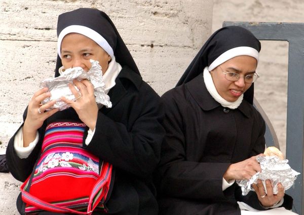 Two nuns eat their sandwiches during the Sunday Angelus, recited by Monsignor Leonardo Sandri at St Peter's Square in the Vatican on 13 March 2005. They were there to see Pope John Paul II deliver his first live address since undergoing emergency surgery the month before. On 2 April, the monsignor announced to the world the death of the 84-year-old Pope. - Sputnik International