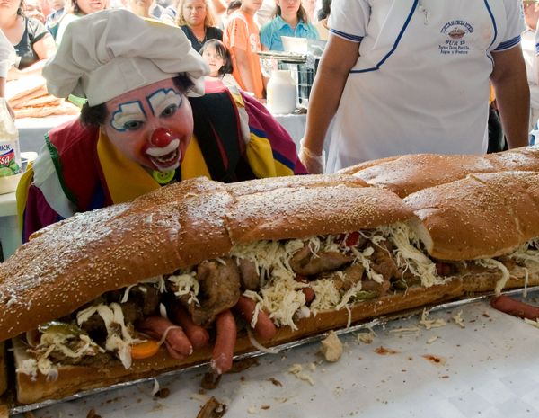A clown gazes at a 46-metre 'torta' (Mexican sandwich) during the annual 'Torta Festival' in Mexico City, on 31 July 2009. More than 200 people helped to make the giant sandwich, which includes meat, avocado, mole (Mexican spicy sauce), turkey, tomatoes, beans, ham and different types of cheese as they attempt to break the record for the longest 'torta'. - Sputnik International