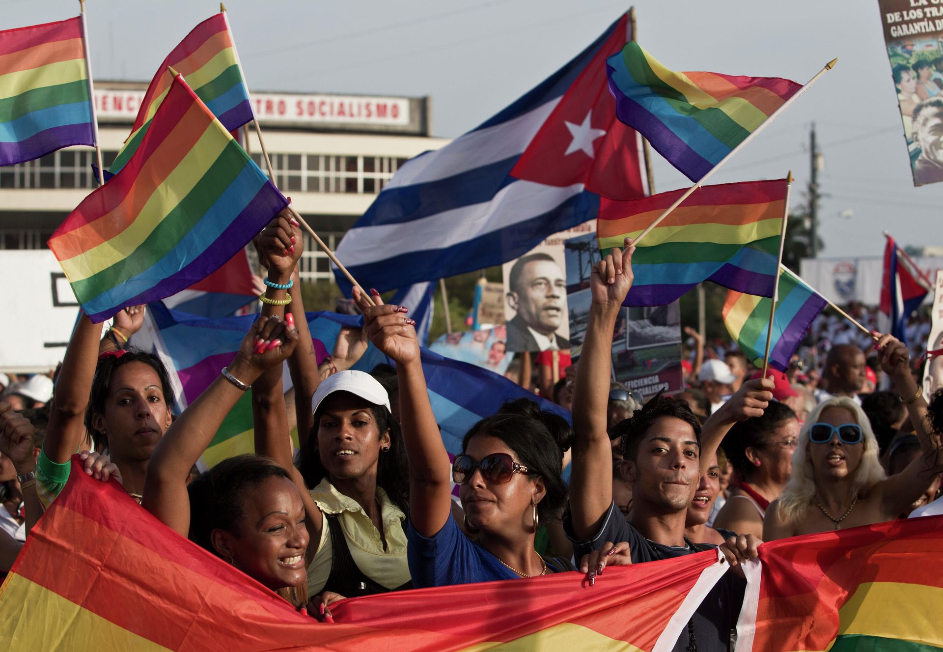 LGBT community members march waving representations of Cuba's national flag and rainbow flags during May Day march in Havana, Cuba, Thursday, May 1, 2014. Cuba marks each May Day not with protests but with massive marches organized by workplaces, schools and government. Thousands of islanders filed through Havana's Revolution Plaza on Thursday to a soundtrack of congas, drums and cries of Long live the revolution! LGBT community members march waving representations of Cuba's national flag and rainbow flags during May Day march in Havana, Cuba, Thursday, May 1, 2014. Cuba marks each May Day not with protests but with massive marches organized by workplaces, schools and government. Thousands of islanders filed through Havana's Revolution Plaza on Thursday to a soundtrack of congas, drums and cries of Long live the revolution! - Sputnik International, 1920, 05.11.2021