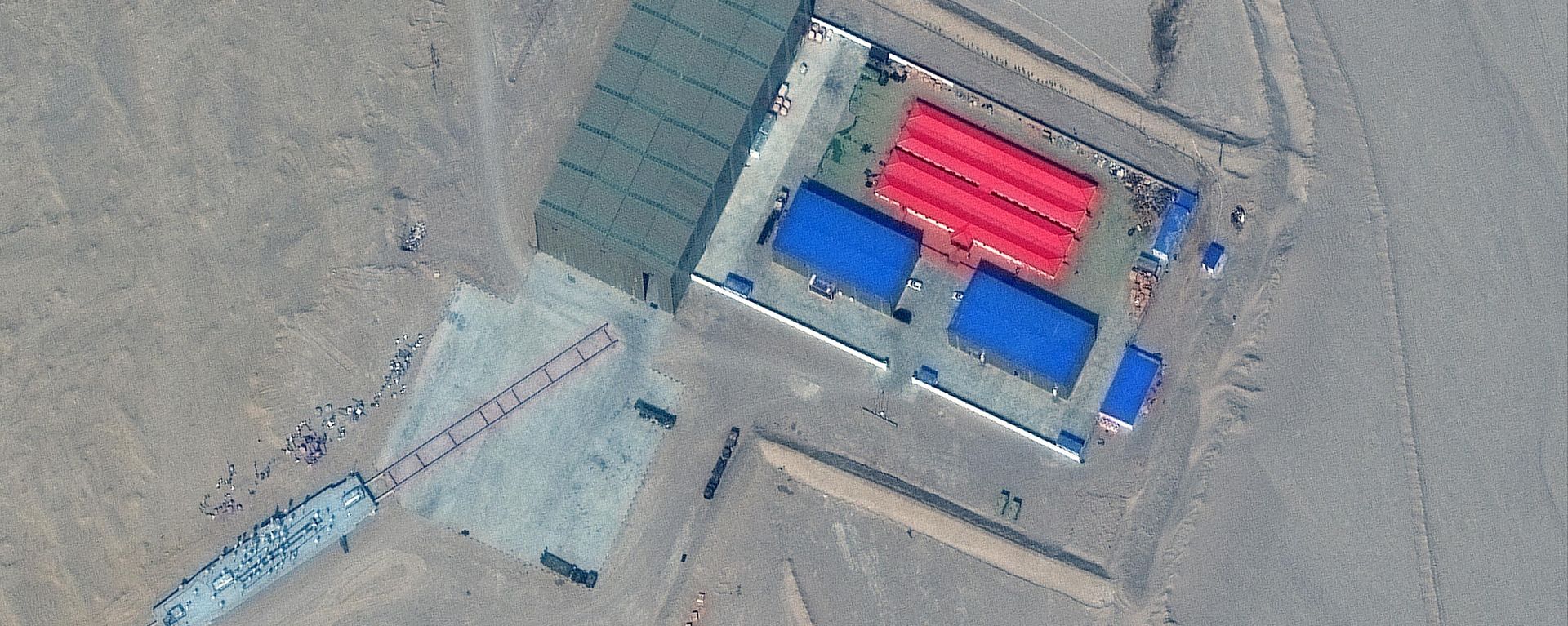 This handout satellite image released by Maxar Technologies on November 8, 2021 shows a rail terminus and a target storage building in Ruoqiang county in the Taklamakan Desert, China's western Xinjiang region on October 8, 2021 - Sputnik International, 1920, 08.11.2021