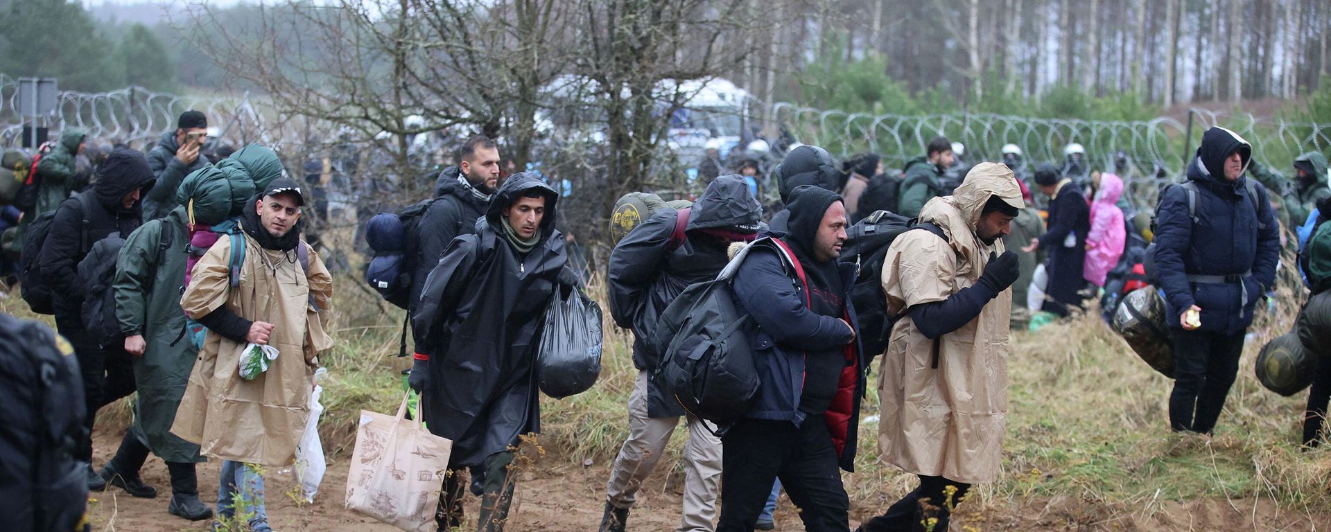 Migrants gather near a barbed wire fence in an attempt to cross the border with Poland in the Grodno region, Belarus November 8, 2021 Migrants gather near a barbed wire fence in an attempt to cross the border with Poland in the Grodno region, Belarus November 8, 2021 - Sputnik International, 1920, 09.11.2021
