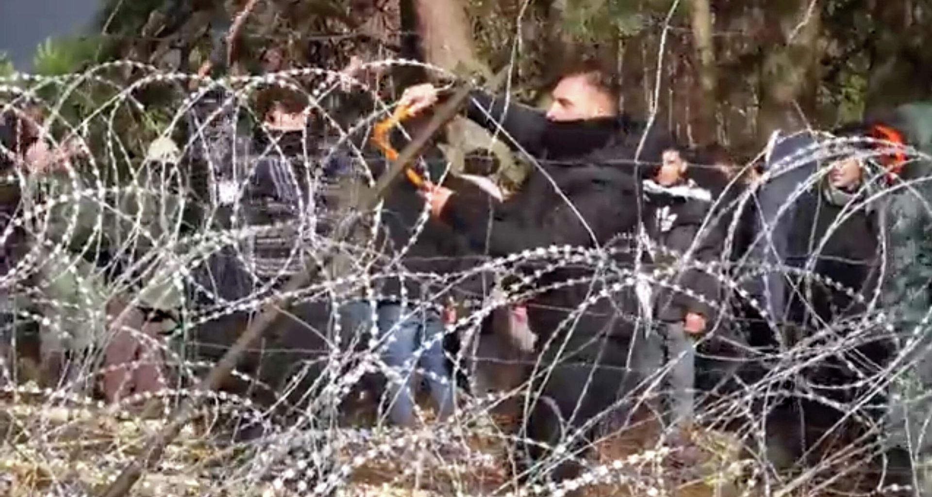 Migrants use wire cutters to cut the barbed wire as they try to cross the Belarus/Poland border near Kuznica Bialostocka, Poland, in this video-grab released by the Polish Defence Ministry, November 8, 2021 Migrants use wire cutters to cut the barbed wire as they try to cross the Belarus/Poland border near Kuznica Bialostocka, Poland, in this video-grab released by the Polish Defence Ministry, November 8, 2021 - Sputnik International, 1920, 10.11.2021