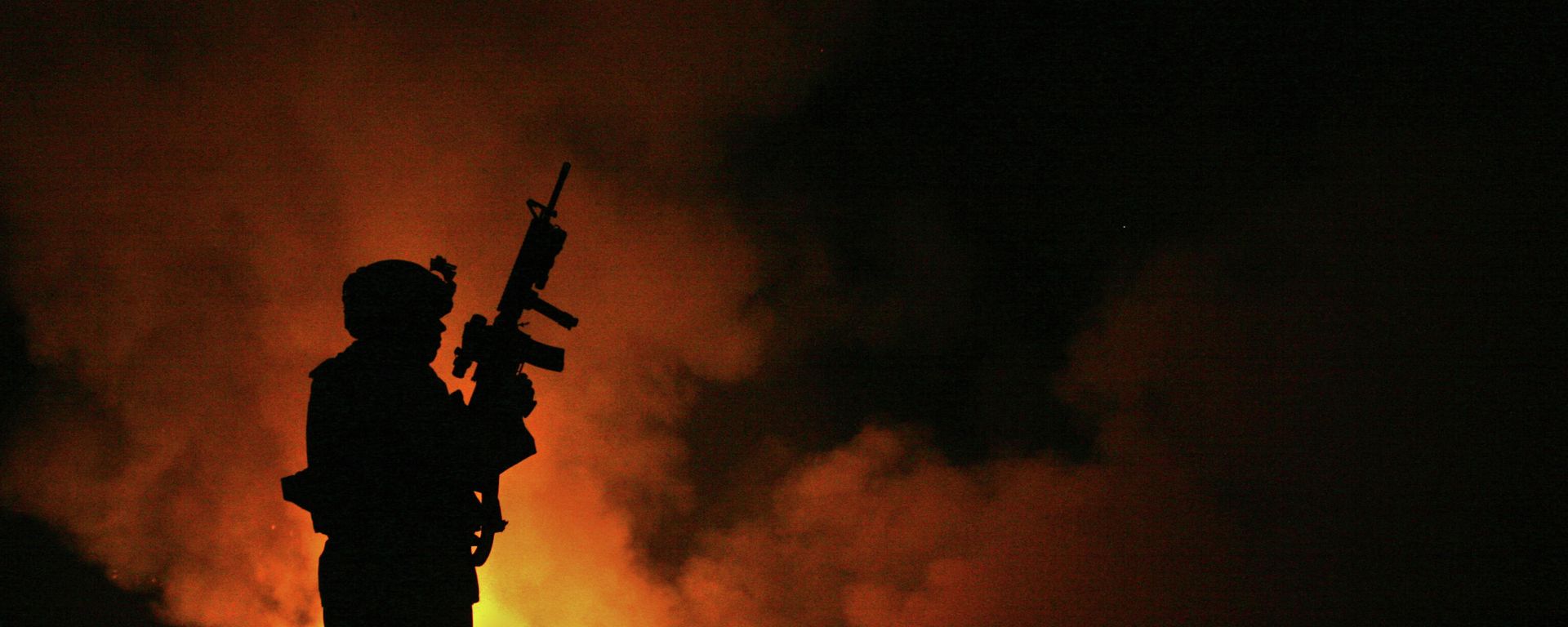 Sgt. Robert B. Brown from Fayetteville, N.C. with Regimental Combat Team 6, Combat Camera Unit watches over the civilian Fire Fighters at the burn pit as smoke and flames rise into the night sky behind him on May 25th, 2007. Sgt. Robert B. Brown from Fayetteville, N.C. with Regimental Combat Team 6, Combat Camera Unit watches over the civilian Fire Fighters at the burn pit as smoke and flames rise into the night sky behind him on May 25th, 2007. - Sputnik International, 1920, 12.11.2023