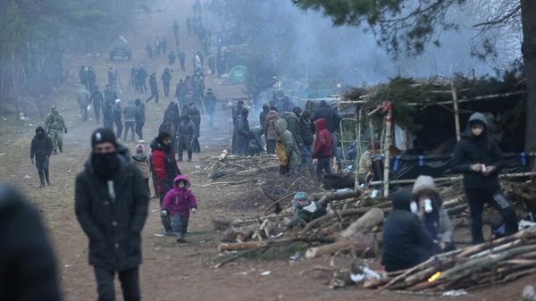 People gather in a migrants' makeshift camp on the Belarusian-Polish border in the Grodno region, Belarus November 14, 2021. Oksana Manchuk/BelTA/Handout via REUTERS  ATTENTION EDITORS - THIS IMAGE HAS BEEN SUPPLIED BY A THIRD PARTY. NO RESALES. NO ARCHIVES. MANDATORY CREDIT. - Sputnik International