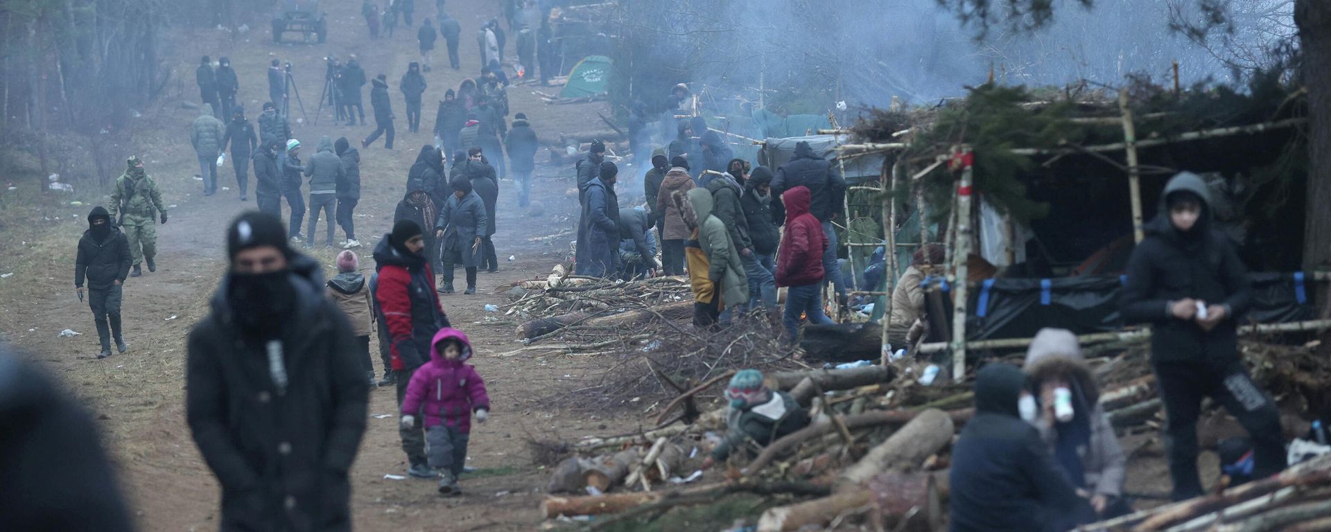 People gather in a migrants' makeshift camp on the Belarusian-Polish border in the Grodno region, Belarus November 14, 2021. Oksana Manchuk/BelTA/Handout via REUTERS ATTENTION EDITORS - THIS IMAGE HAS BEEN SUPPLIED BY A THIRD PARTY. NO RESALES. NO ARCHIVES. MANDATORY CREDIT. People gather in a migrants' makeshift camp on the Belarusian-Polish border in the Grodno region, Belarus November 14, 2021. Oksana Manchuk/BelTA/Handout via REUTERS ATTENTION EDITORS - THIS IMAGE HAS BEEN SUPPLIED BY A THIRD PARTY. NO RESALES. NO ARCHIVES. MANDATORY CREDIT. - Sputnik International, 1920, 17.11.2021