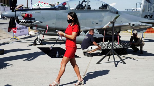 A woman walks past a Beechcraft AT-6 Wolverine light-attack aircraft as crew install a device to its wing at the Dubai Air Show in Dubai, United Arab Emirates, Sunday, Nov. 14, 2021 - Sputnik International
