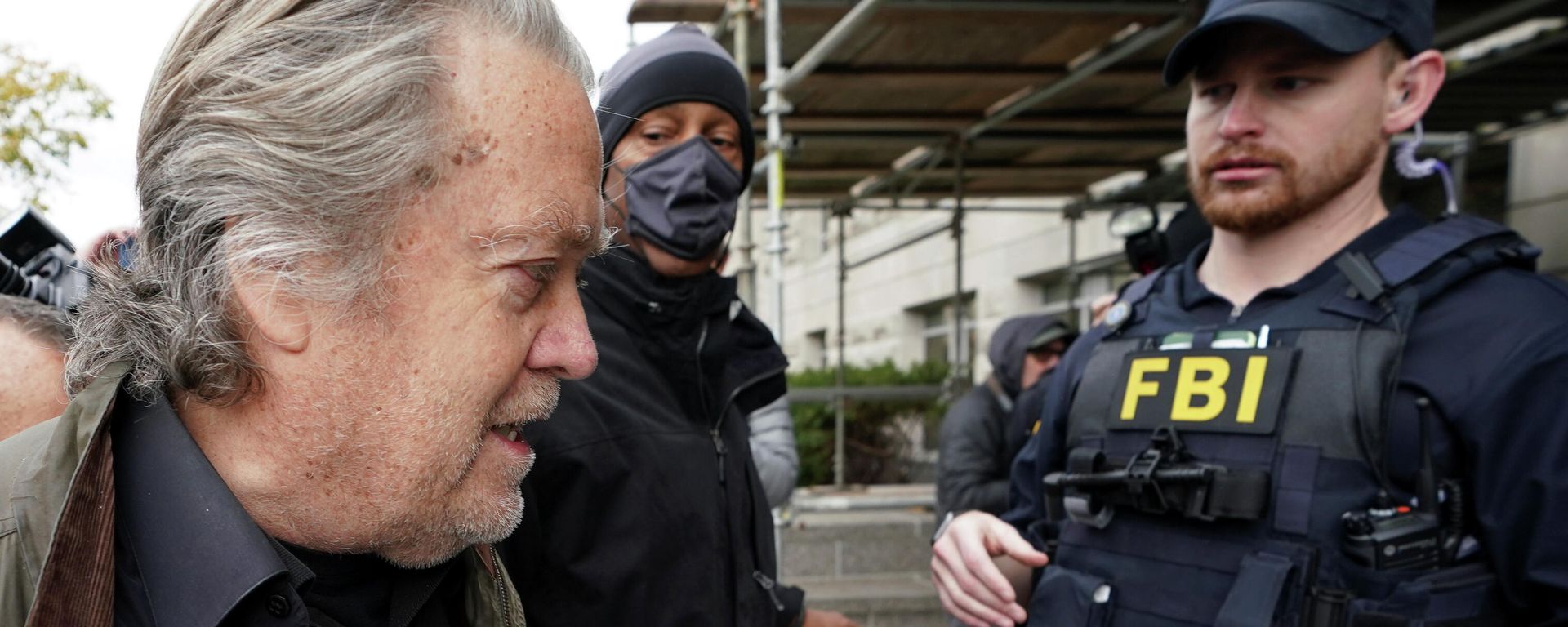 An FBI officer observes as Steve Bannon, talk show host and former White House advisor to former President Donald Trump, arrives at the FBI's Washington field office to turn himself in to federal authorities after being indicted for refusal to comply with a congressional subpoena over the January 6 attacks on the U.S. Capitol in Washington, U.S., November 15, 2021. An FBI officer observes as Steve Bannon, talk show host and former White House advisor to former President Donald Trump, arrives at the FBI's Washington field office to turn himself in to federal authorities after being indicted for refusal to comply with a congressional subpoena over the January 6 attacks on the U.S. Capitol in Washington, U.S., November 15, 2021. - Sputnik International, 1920, 15.11.2021