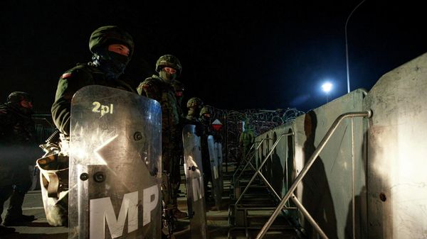 Polish Territorial Defence Forces secure additional fence where hundreds of migrants camp at the Belarus side of Kuznica Bialostocka-Bruzgi border crossing, Poland in this photograph released by the Territorial Defence Forces, November 15, 2021. - Sputnik International
