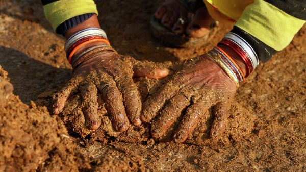 An Indian village woman makes cow dung cakes in Allahabad, India, Wednesday, Dec. 22, 2010 - Sputnik International