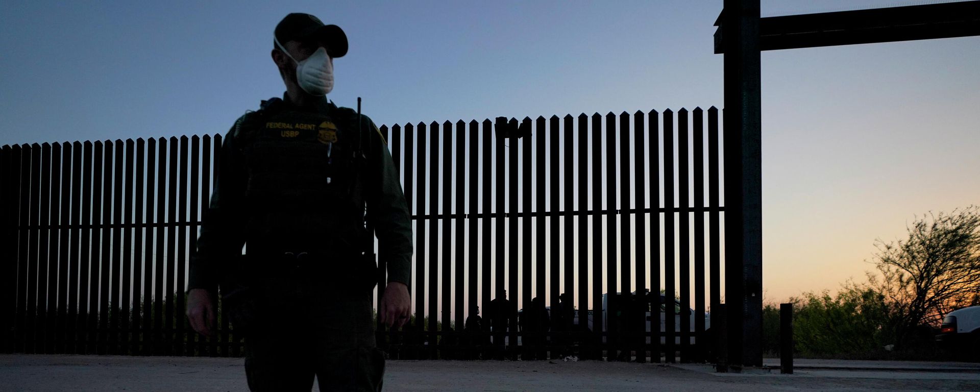 In this March 21, 2021 file photo, a U.S. Customs and Border Protection agent looks on near a gate on the U.S.-Mexico border wall as agents take migrants into custody, in Abram-Perezville, Texas. - Sputnik International, 1920, 29.06.2022