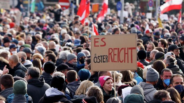 Demonstrators hold flags and placards as they gather to protest against the coronavirus disease (COVID-19) measures in Vienna, Austria, November 20, 2021. The placard reads: It is enough in Austria. REUTERS/Leonhard Foeger - Sputnik International