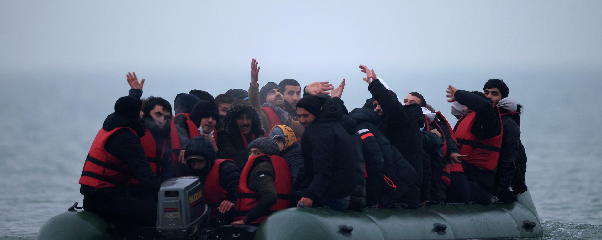 A group of more than 40 migrants react as they succeeded to get on an inflatable dinghy, to leave the coast of northern France and to cross the English Channel, near Wimereux, France, November 24, 2021. - Sputnik International, 1920, 29.11.2021