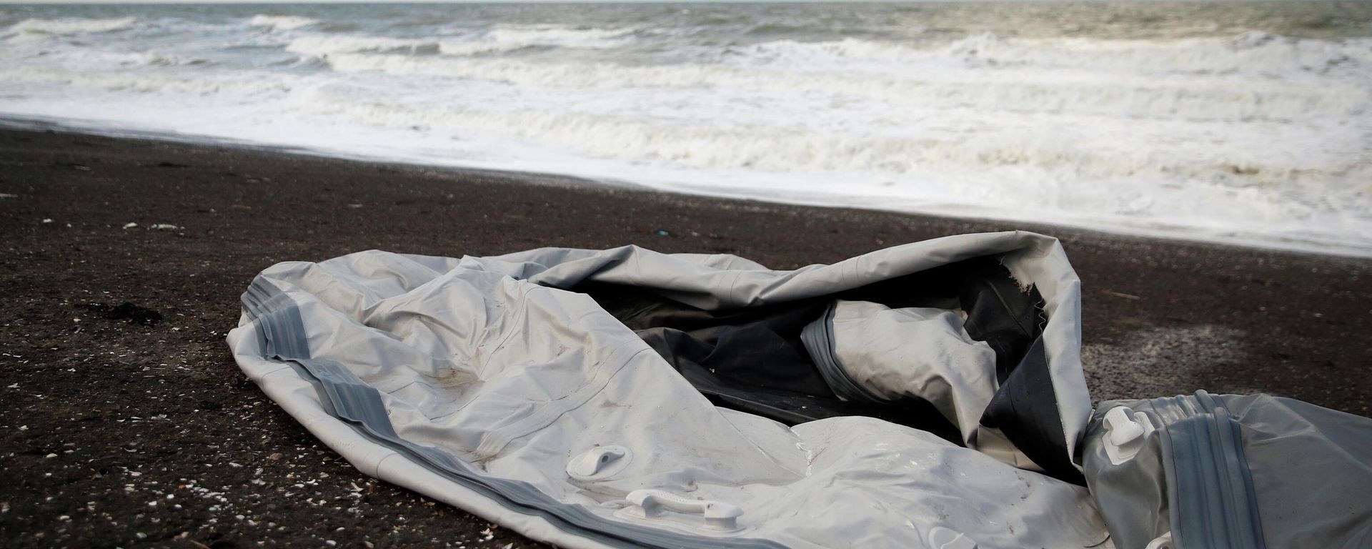A damaged inflatable dinghy is seen on Loon Beach, the day after 27 migrants died when their dinghy deflated as they attempted to cross the English Channel, in Dunkerque near Calais, France, November 25, 2021. A damaged inflatable dinghy is seen on Loon Beach, the day after 27 migrants died when their dinghy deflated as they attempted to cross the English Channel, in Dunkerque near Calais, France, November 25, 2021. - Sputnik International, 1920, 25.11.2021
