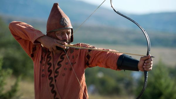 Participant of the Scolotoi Nomad Camp reenactment shoots a bow at the Crimean military historical festival in Pervomaika, Balaklava District - Sputnik International