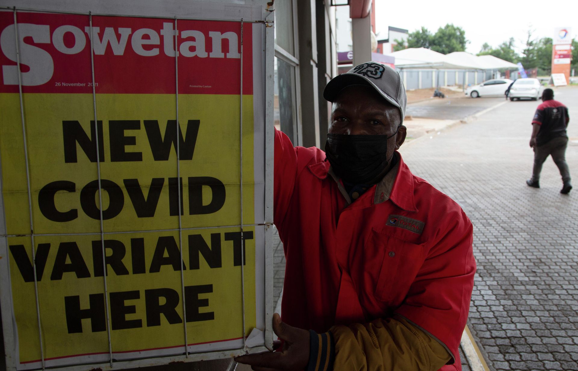 A petrol attendant stands next to a newspaper headline in Pretoria, South Africa, Saturday, Nov. 27, 2021. - Sputnik International, 1920, 06.12.2021