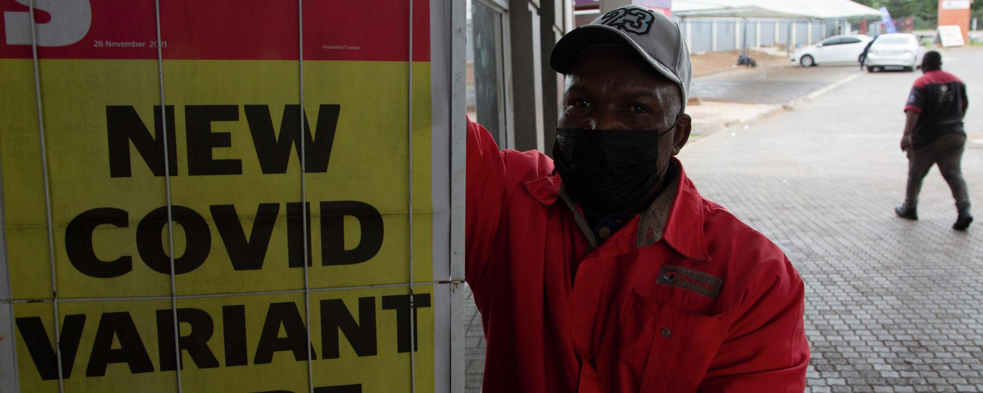 A petrol attendant stands next to a newspaper headline in Pretoria, South Africa, Saturday, Nov. 27, 2021. - Sputnik International, 1920, 27.11.2021
