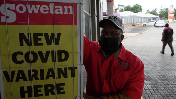 A petrol attendant stands next to a newspaper headline in Pretoria, South Africa, Saturday, Nov. 27, 2021. - Sputnik International