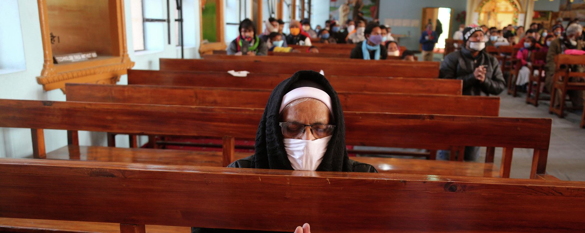 An Indian Christian wearing a face mask as a precaution against the coronavirus prays at Saint Mary's Cathedral on Christmas in Jammu, India, Friday, Dec. 25, 2020 An Indian Christian wearing a face mask as a precaution against the coronavirus prays at Saint Mary's Cathedral on Christmas in Jammu, India, Friday, Dec. 25, 2020 - Sputnik International, 1920, 29.11.2021