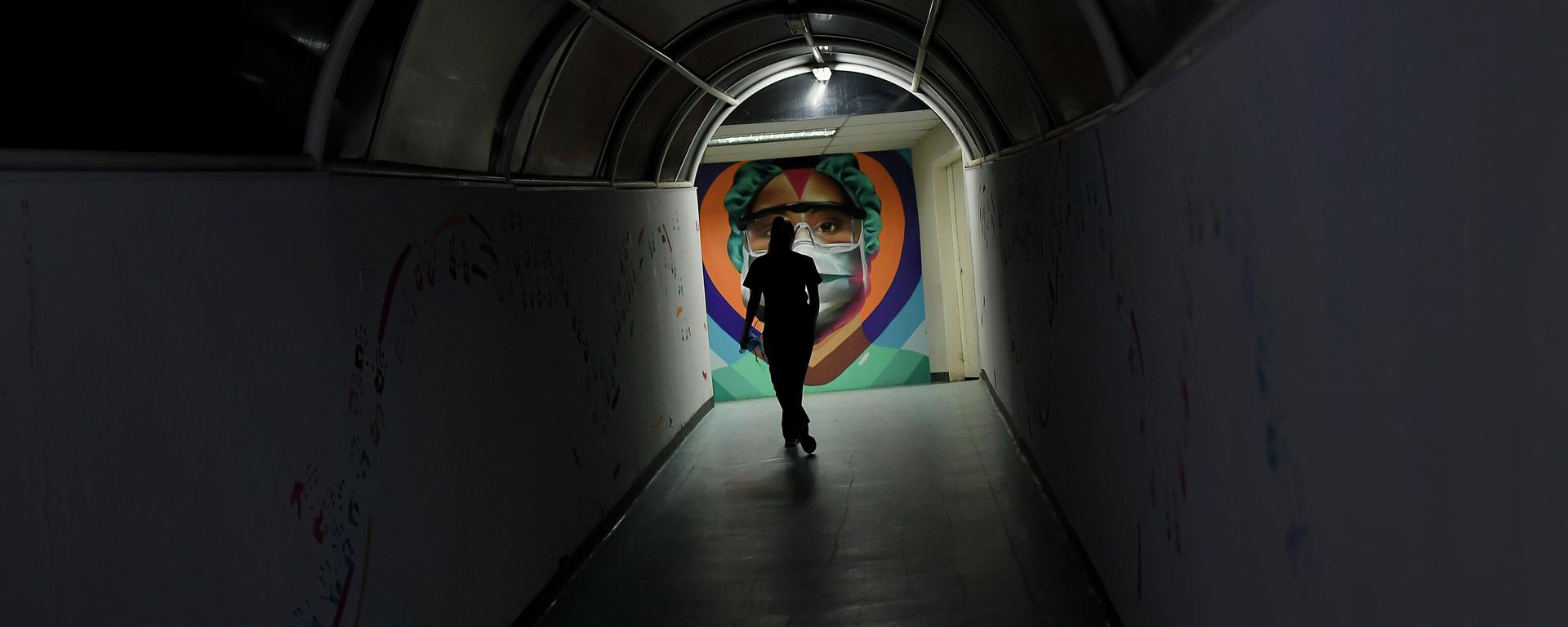 A health worker walks past a mural by the graffiti artist Badsura, at the Ana Francisca Perez de Leon II public Hospital in Caracas, Venezuela, Saturday, March 27, 2021 A health worker walks past a mural by the graffiti artist Badsura, at the Ana Francisca Perez de Leon II public Hospital in Caracas, Venezuela, Saturday, March 27, 2021 - Sputnik International, 1920, 29.11.2021