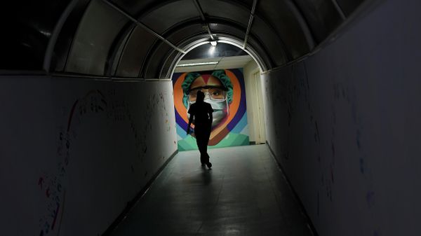 A health worker walks past a mural by the graffiti artist Badsura, at the Ana Francisca Perez de Leon II public Hospital in Caracas, Venezuela, Saturday, March 27, 2021 - Sputnik International