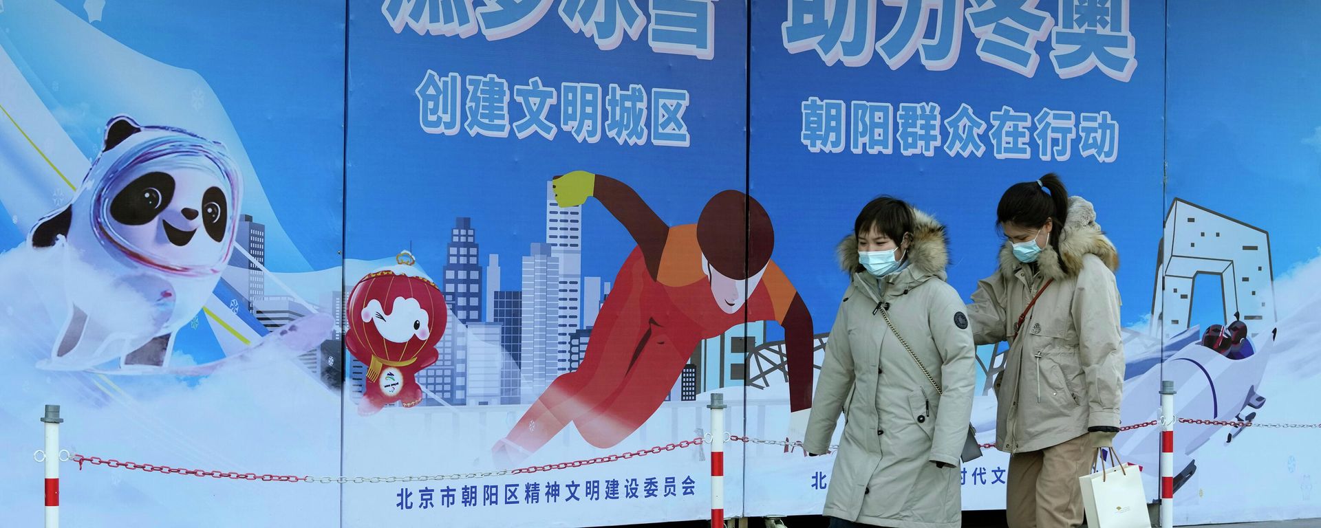 Residents wearing masks pass by propaganda boards promoting the upcoming Beijing Winter Olympics in Beijing, China, Monday, Nov. 22, 2021 Residents wearing masks pass by propaganda boards promoting the upcoming Beijing Winter Olympics in Beijing, China, Monday, Nov. 22, 2021 - Sputnik International, 1920, 07.12.2021