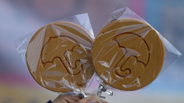 A woman poses with Dalgona candies for a photograph outside a shop in Seoul, South Korea, Saturday, Oct. 9, 2021. - Sputnik International