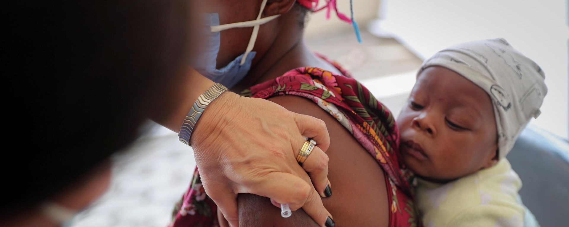 Healthcare worker administers the coronavirus disease (COVID-19) vaccine to a woman, in Johannesburg - Sputnik International, 1920, 06.12.2021