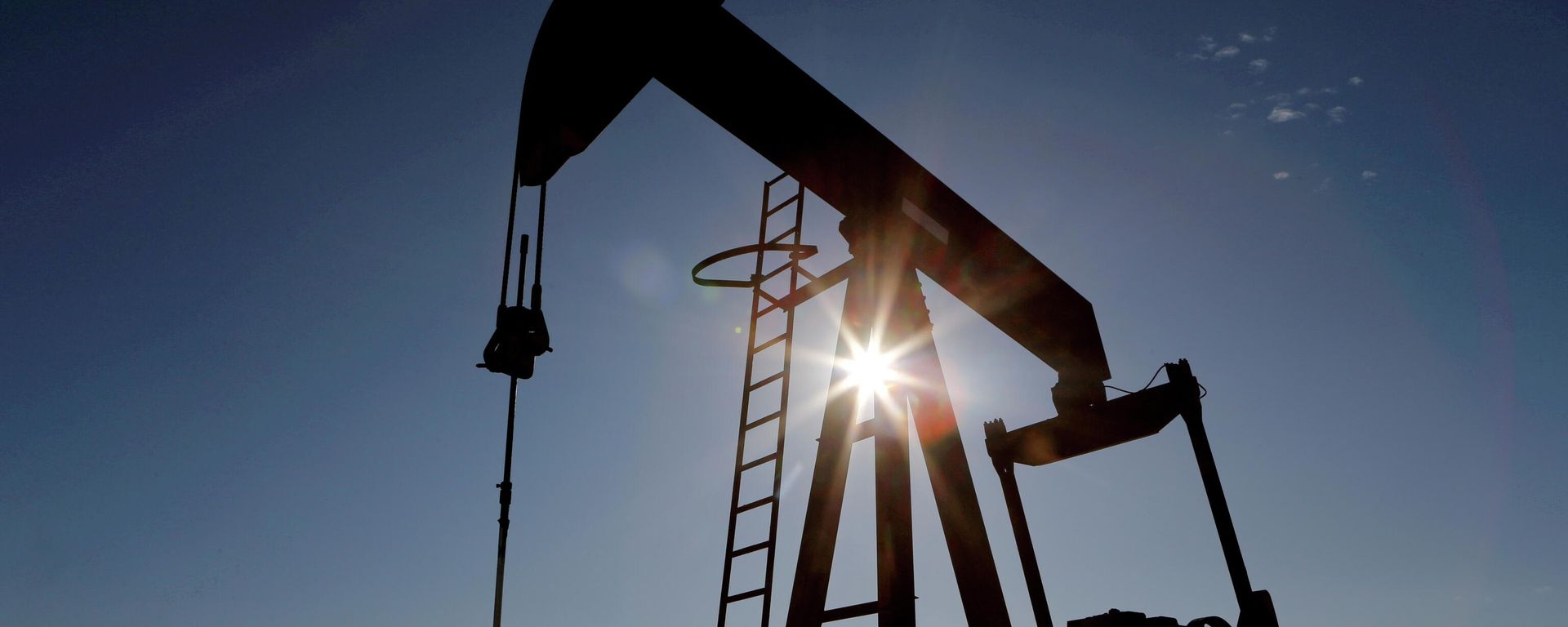 The sun is seen behind a crude oil pump jack in the Permian Basin in Loving County, Texas, U.S., November 22, 2019. - Sputnik International, 1920, 07.12.2021