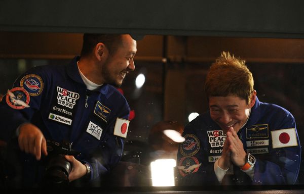 Japanese space tourists, businessman Yusaku Maezawa (L) and his aide Yozo Hirano wave goodbye from a bus that carries them to the launch site at Baikonur cosmodrome, 8 December 2021.  - Sputnik International
