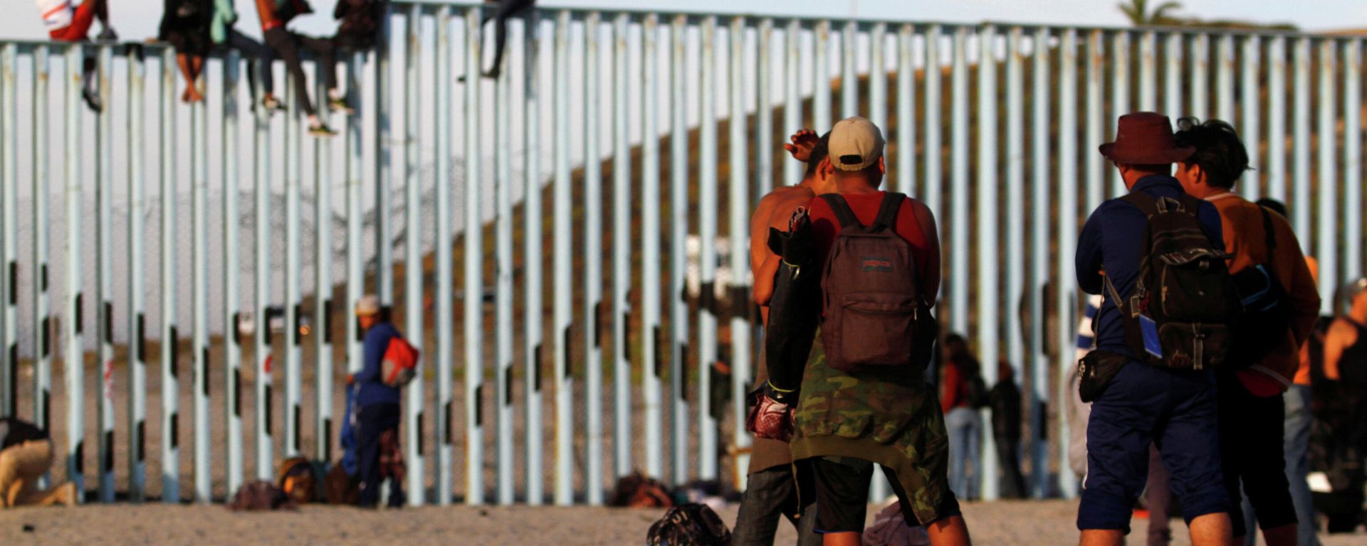 Migrants, part of a caravan of thousands trying to reach the U.S., gather at the border fence between Mexico and the United States after arriving in Tijuana, Mexico November 13, 2018 Migrants, part of a caravan of thousands trying to reach the U.S., gather at the border fence between Mexico and the United States after arriving in Tijuana, Mexico November 13, 2018 - Sputnik International, 1920, 23.12.2021