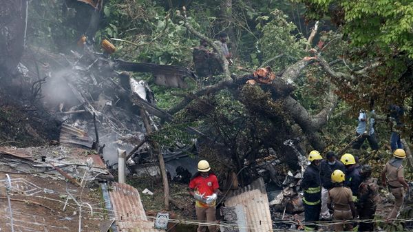 Rescuers stand near the debris of the Russian-made Mi-17V5 helicopter after it crashed near the town of Coonoor in the southern state of Tamil Nadu, India, December 8, 2021 - Sputnik International
