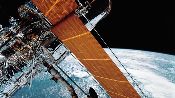 FILE - In this April 25, 1990 photograph provided by NASA, most of the giant Hubble Space Telescope can be seen as it is suspended in space by Discovery's Remote Manipulator System (RMS) following the deployment of part of its solar panels and antennae.   The Hubble Space Telescope should be back in action soon, Friday, July 16, 2021, following a tricky, remote repair job by NASA - Sputnik International