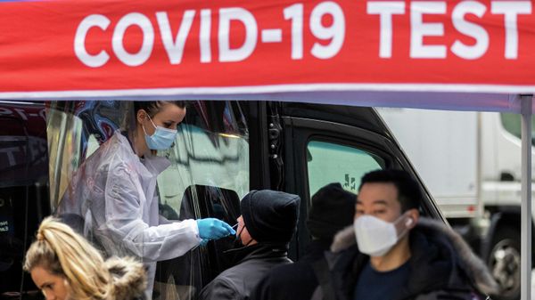 A man is tested for the coronavirus disease (COVID-19) at a mobile COVID-19 testing unit, as pedestrians make their way in the sidewalk during the spread of the Omicron coronavirus variant in Manhattan, New York, U.S., December 8, 2021. - Sputnik International