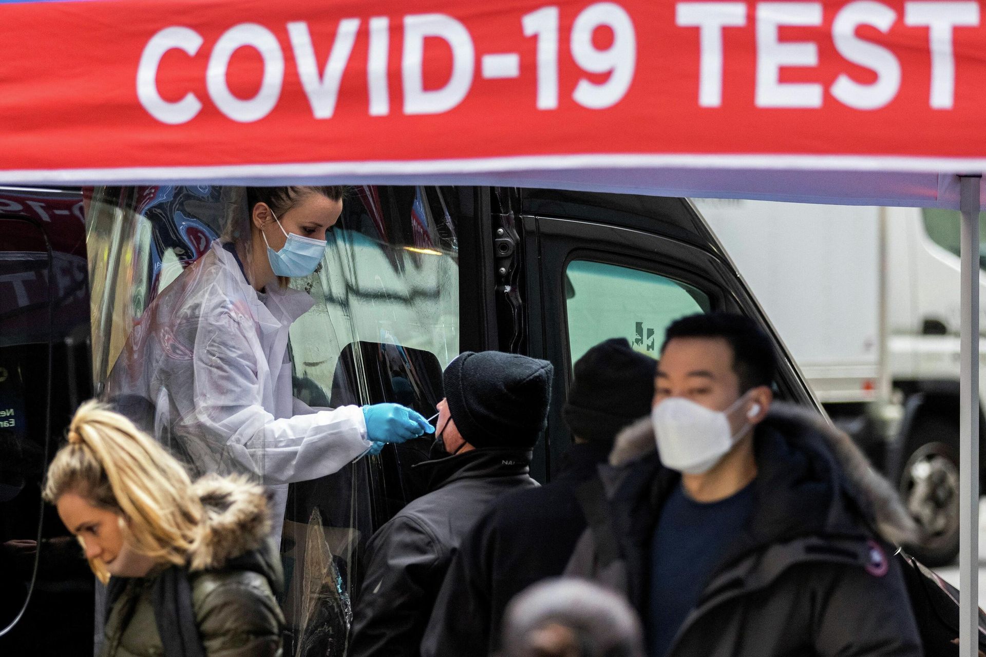 A man is tested for the coronavirus disease (COVID-19) at a mobile COVID-19 testing unit, as pedestrians make their way in the sidewalk during the spread of the Omicron coronavirus variant in Manhattan, New York, U.S., December 8, 2021. - Sputnik International, 1920, 20.12.2021