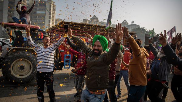 Indian farmers are showered with flower petals as they dance while leaving the protest site in Singhu, on the outskirts of New Delhi, India, Saturday, Dec. 11, 2021.  - Sputnik International