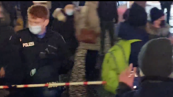 A screenshot from a video allegedly showing a policeman in Frankfurt, Germany said to be measuring the distance between people on the streets with a ruler A screenshot from a video allegedly showing a policeman in Frankfurt, Germany said to be measuring the distance between people on the streets with a ruler - Sputnik International