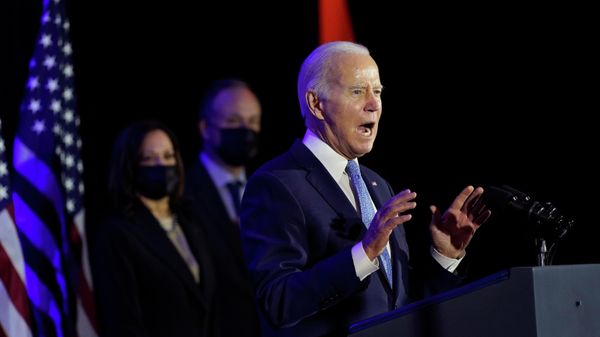 President Joe Biden speaks at a Democratic National Committee holiday party, Tuesday, Dec. 14, 2021, in Washington, as Vice President Kamala Harris and second gentleman Doug Emhoff listen - Sputnik International