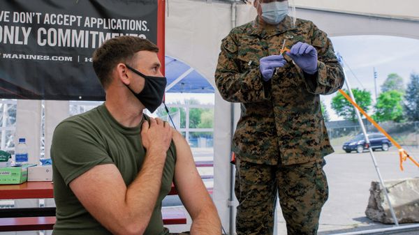 U.S. Navy Lt. Craig Wilcox, a company commander assigned to Alpha Company, 1st Medical Battalion, 1st Marine Logistics Group (MLG), I Marine Expeditionary Force (MEF), left, waits for U.S. Marine Corps Gunnery Sgt. Rodolfo Mena, a maintenance management chief assigned to Combat Logistics Regiment 1, 1st MLG, I MEF, right, to administer a COVID-19 vaccine at the walk in clinic at the Community Vaccination Center (CVC) at the Jackson County Expo in Central Point, Oregon, April 29, 2021. U.S. Northern Command, through U.S. Army North, remains committed to providing continued, flexible Department of Defense support to the Federal Emergency Management Agency as part of the whole-of-government response to COVID-19 - Sputnik International