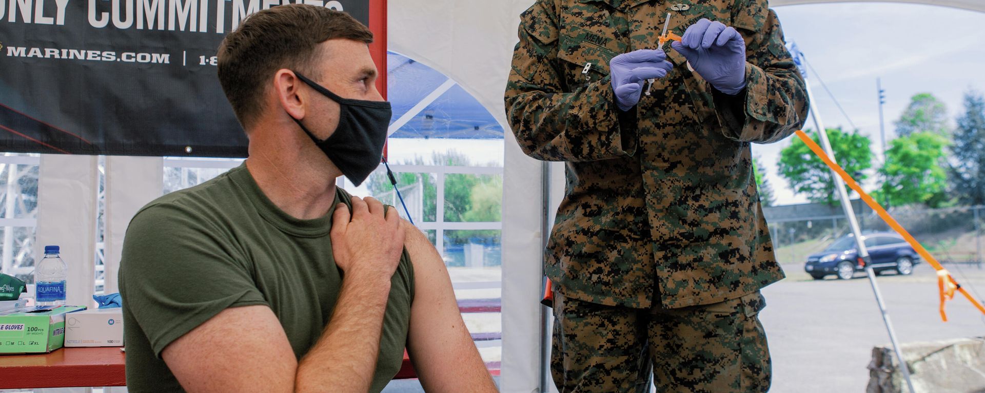 U.S. Navy Lt. Craig Wilcox, a company commander assigned to Alpha Company, 1st Medical Battalion, 1st Marine Logistics Group (MLG), I Marine Expeditionary Force (MEF), left, waits for U.S. Marine Corps Gunnery Sgt. Rodolfo Mena, a maintenance management chief assigned to Combat Logistics Regiment 1, 1st MLG, I MEF, right, to administer a COVID-19 vaccine at the walk in clinic at the Community Vaccination Center (CVC) at the Jackson County Expo in Central Point, Oregon, April 29, 2021. U.S. Northern Command, through U.S. Army North, remains committed to providing continued, flexible Department of Defense support to the Federal Emergency Management Agency as part of the whole-of-government response to COVID-19 - Sputnik International, 1920, 16.12.2021