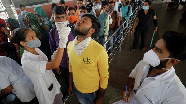 A healthcare worker collects a swab sample from a passenger as others wait for their turn upon arrival at a railway station during a rapid antigen testing drive for the coronavirus disease (COVID-19) in Ahmedabad, India, November 30, 2021. A healthcare worker collects a swab sample from a passenger as others wait for their turn upon arrival at a railway station during a rapid antigen testing drive for the coronavirus disease (COVID-19) in Ahmedabad, India, November 30, 2021. - Sputnik International