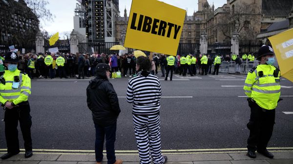 People take part in a protest against COVID-19 vaccine passports and other policies outside the Houses of Parliament in London, Monday, Dec. 13, 2021.  - Sputnik International