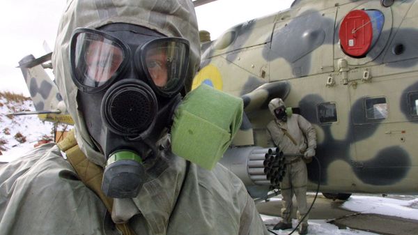 Ukrainian soldier wears a protective suit and a gas mask during exercises  - Sputnik International