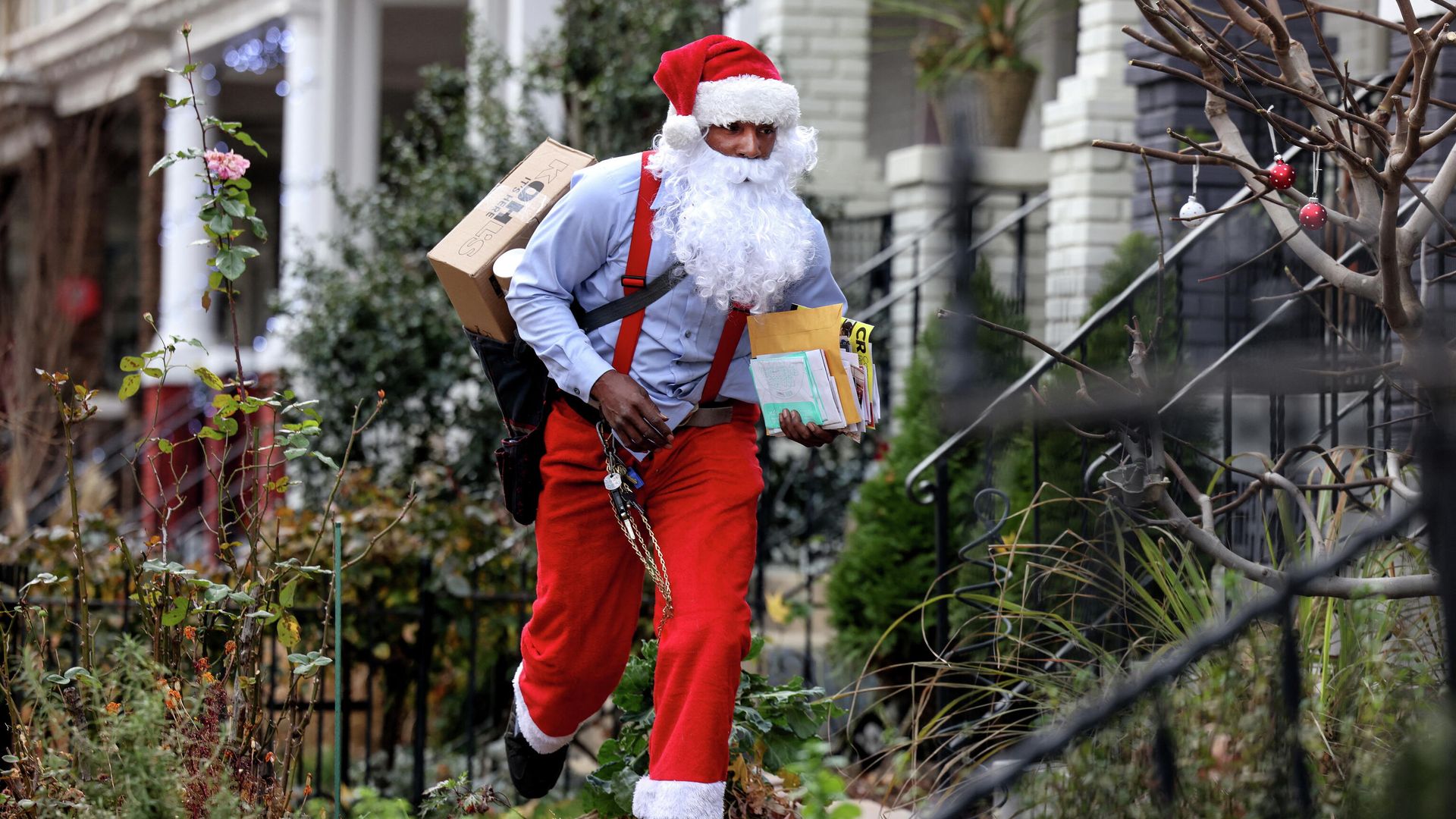 Postal worker Eddie Smith, dressed as Santa Claus, waves to a neighbor on his mail route in Washington, U.S., December 21, 2021 Postal worker Eddie Smith, dressed as Santa Claus, waves to a neighbor on his mail route in Washington, U.S., December 21, 2021 - Sputnik International, 1920, 22.12.2021