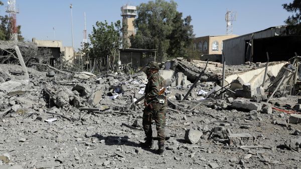 A police trooper walks on the rubble of a building destroyed by Saudi-led air strikes at Sanaa Airport in Sanaa, Yemen December 21, 2021 - Sputnik International