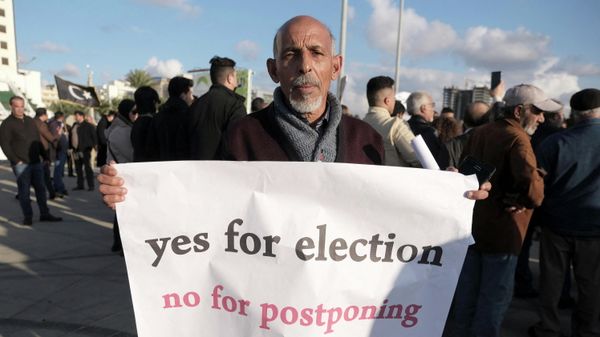 A man holds a banner during a protest against the delay to the Libyan presidential election initially planned for December 24, in Benghazi, Libya  December 24, 2021.  - Sputnik International