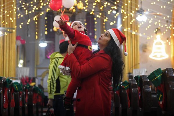 A child dressed as Santa Claus is held up by her mother on Christmas Eve at St. Paul's church in Amritsar, India, on 24 December 2021. A child dressed as Santa Claus is held up by her mother on Christmas Eve at St. Paul's church in Amritsar, India, on 24 December 2021. - Sputnik International