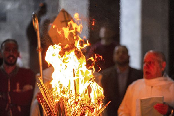 The mitre (hat) and crosier (pastoral staff) of Chaldean Catholic Archbishop of Basra Habib Nafali are seen behind a bonfire during the Christmas eve mass at the Church of Saint Teresa of the Child Jesus in the southern Iraq city of Basra on 24 December 2021. The mitre (hat) and crosier (pastoral staff) of Chaldean Catholic Archbishop of Basra Habib Nafali are seen behind a bonfire during the Christmas eve mass at the Church of Saint Teresa of the Child Jesus in the southern Iraq city of Basra on 24 December 2021. - Sputnik International